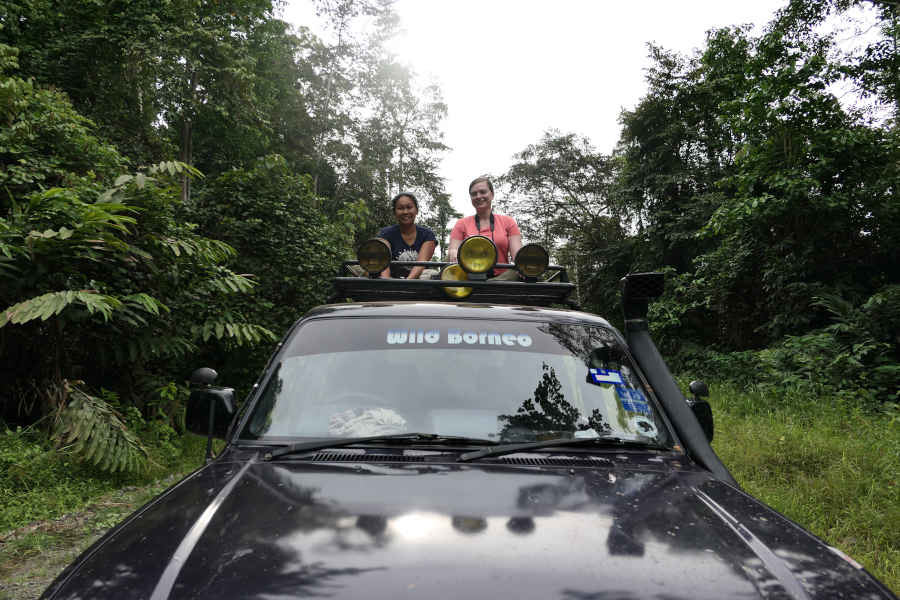 A woman sitting on the top of a car