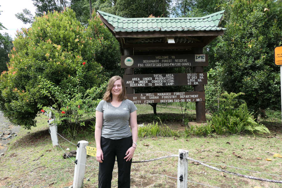 A woman taking a picture in the welcome board